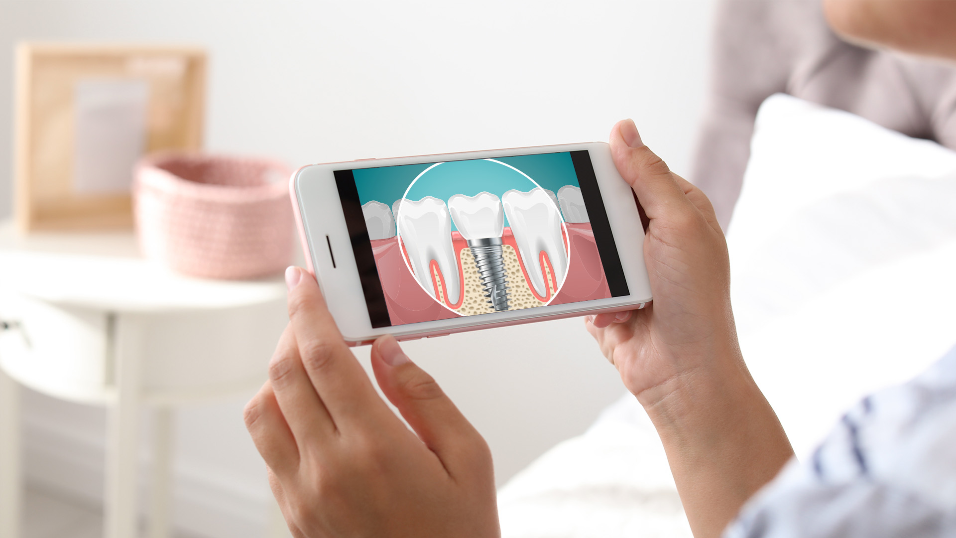 A person holding a smartphone displaying an illustration of a tooth with a visible crack or chip, suggesting dental care or a dental issue being addressed.